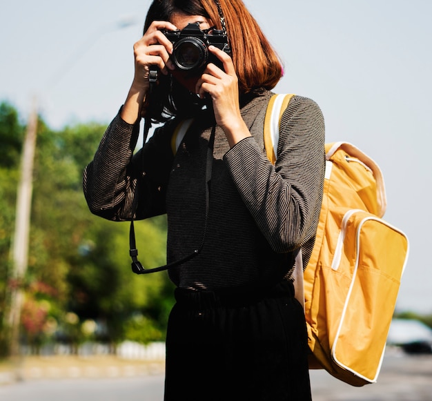 Ragazza che usando la sua macchina fotografica all&#39;aperto