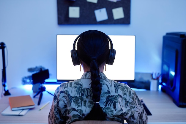 Ragazza che utilizza il computer di notte Vista posteriore