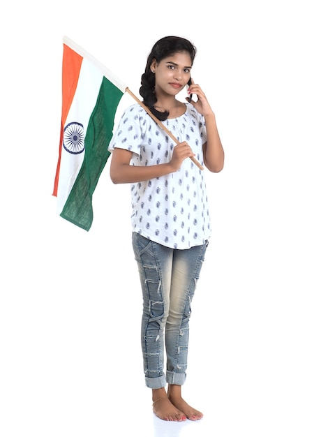 Ragazza che utilizza mobile con bandiera indiana o tricolore sul muro bianco, giorno dell'indipendenza indiana, festa della Repubblica indiana