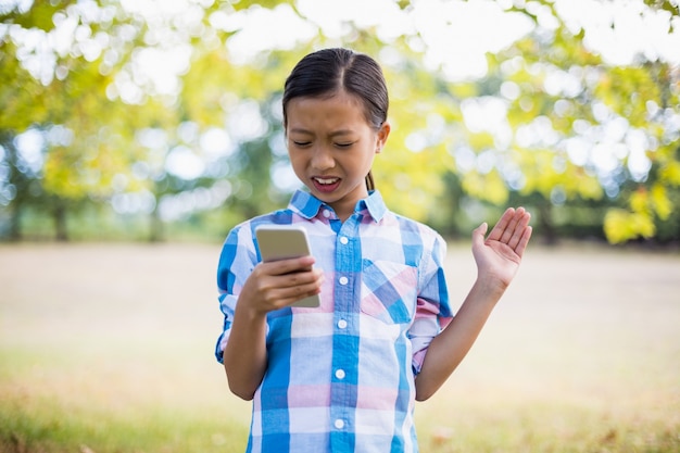 Ragazza che utilizza telefono cellulare nel parco