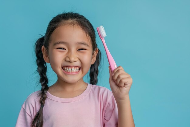 Ragazza cinese con lo spazzolino da denti in mano su uno sfondo blu chiaro