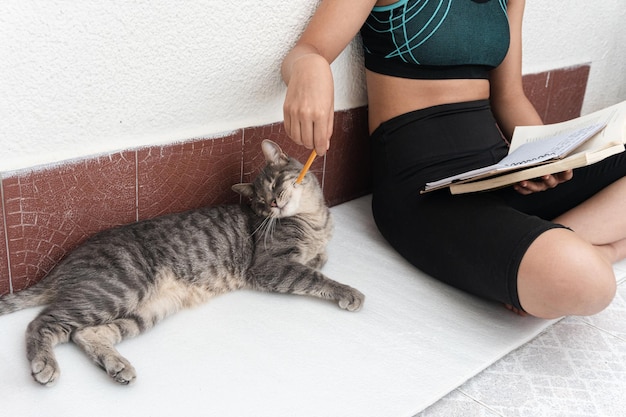 Ragazza colombiana che legge, prende appunti e cura il suo animale domestico. celebrazione della giornata del libro