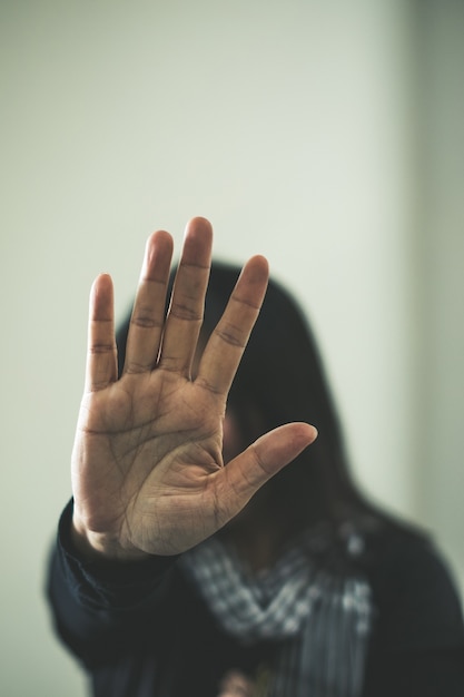 Ragazza colpita. ragazza con lividi sul viso che mostra il segnale di stop