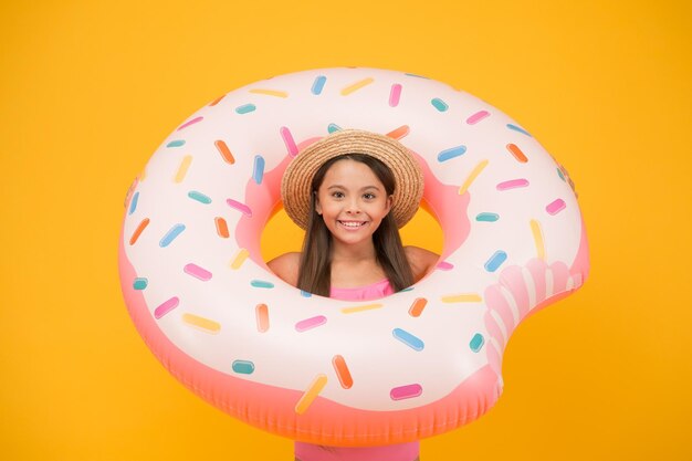 Ragazza con anello di gomma gonfiabile in piscina bambina che va a giocare in acqua divertendosi sulla spiaggia bambino felice sulla spiaggia estiva Rilassarsi in mare divertendosi nel parco acquatico