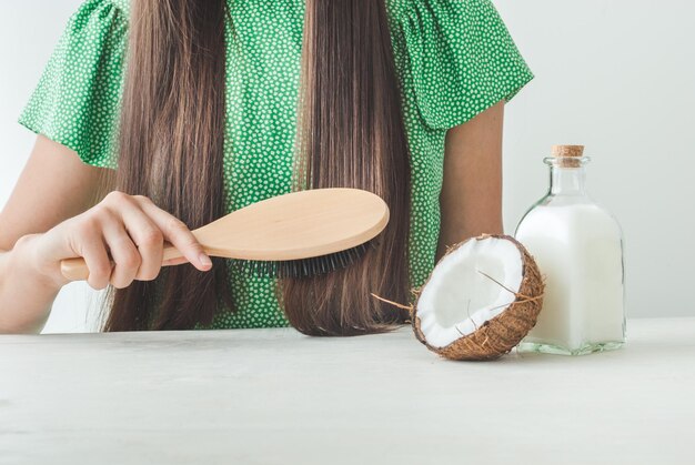 ragazza con bei capelli e olio di cocco per la cura