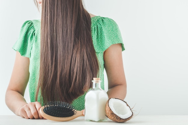 ragazza con bei capelli e olio di cocco per la cura