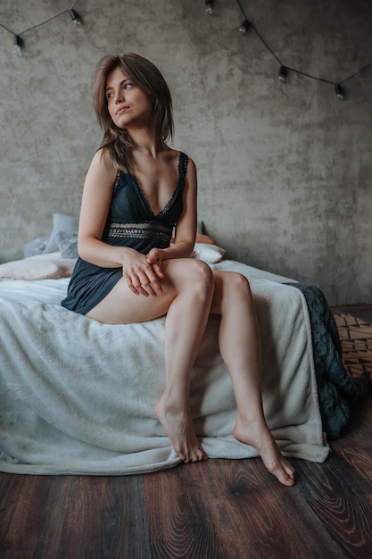 Ragazza con belle gambe seduta sul letto