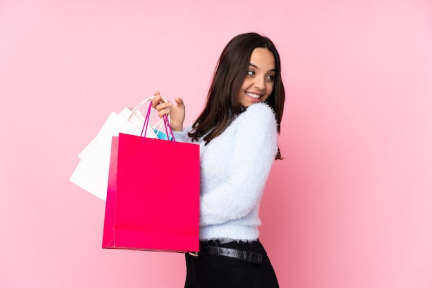 Ragazza con borse della spesa su sfondo isolato