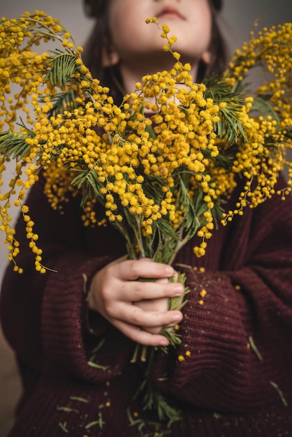 Ragazza con bouquet di mimosa