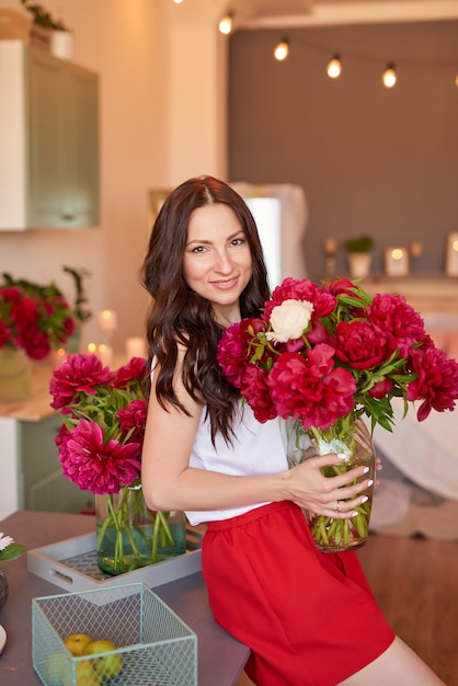 Ragazza con bouquet di peonie. Bouquet di peonie.