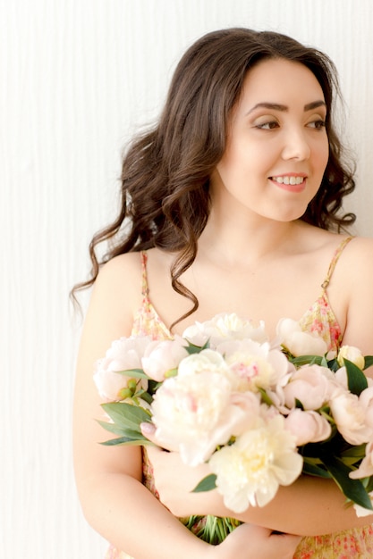 Ragazza con bouquet di peonie