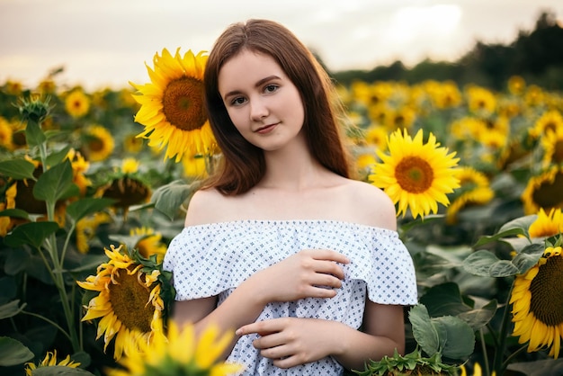 Ragazza con bouquet giallo di un campo di girasoli in fiore