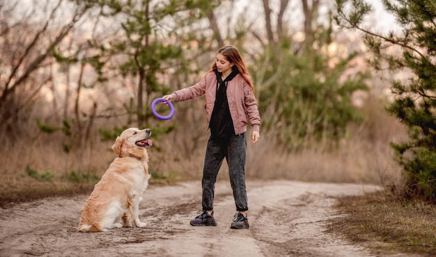 Ragazza con cane golden retriever nel bosco