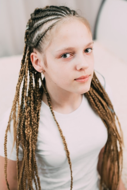 Ragazza con capelli castani e trecce intrecciate con capelli artificiali