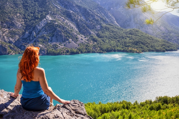 Ragazza con capelli rossi sulla scogliera del canyon