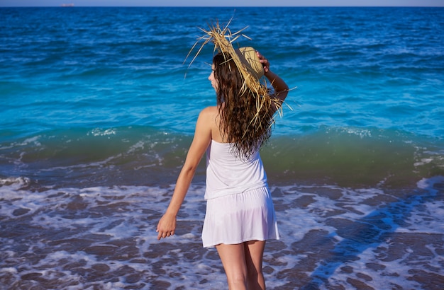 Ragazza con cappello da spiaggia in profilo riva mare