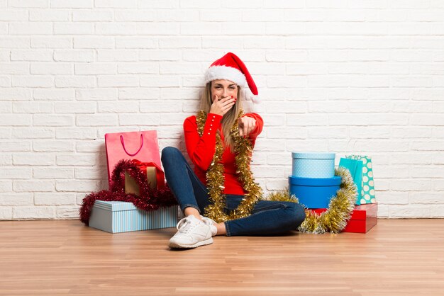 Ragazza con cappello di Natale e molti regali che celebrano le vacanze di Natale