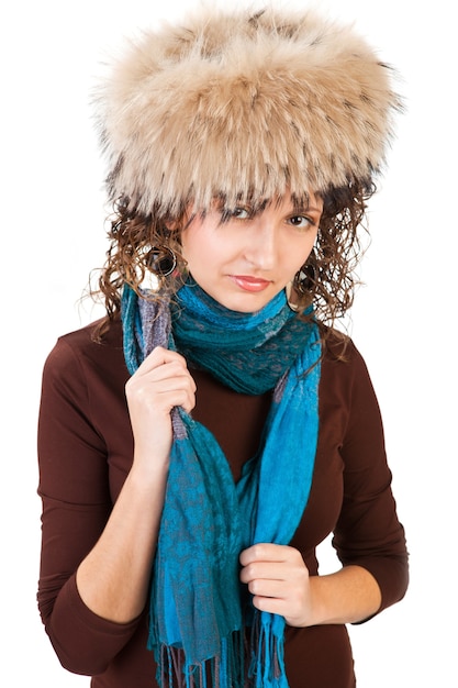 Ragazza con cappello di pelliccia e sciarpa blu isolata su sfondo bianco
