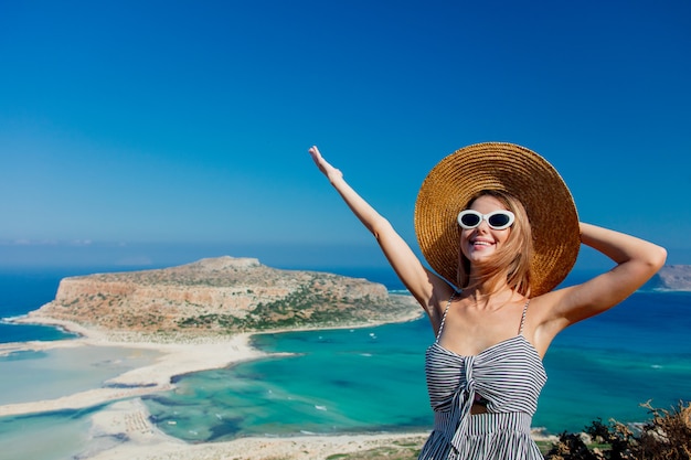 ragazza con cappello e vestito con la costa del mare