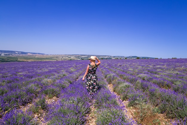 Ragazza con cappello in un campo di lavanda