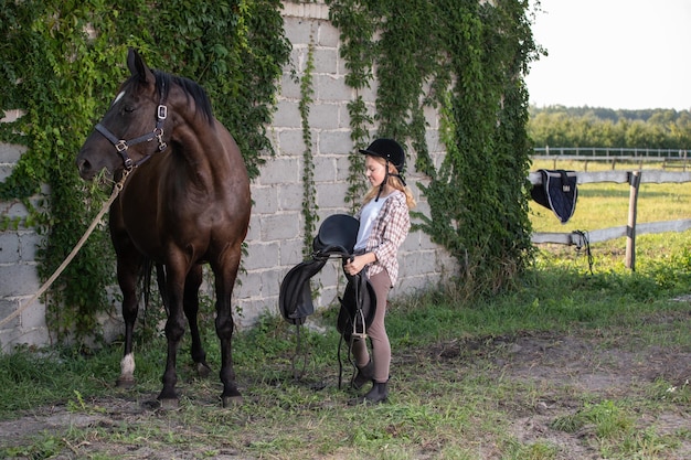 Ragazza con cavallo che si mette in sella per andare a cavallo