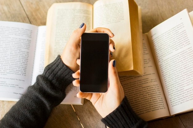 Ragazza con cellulare e libri