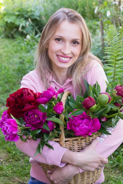 Ragazza con cesto di peonie