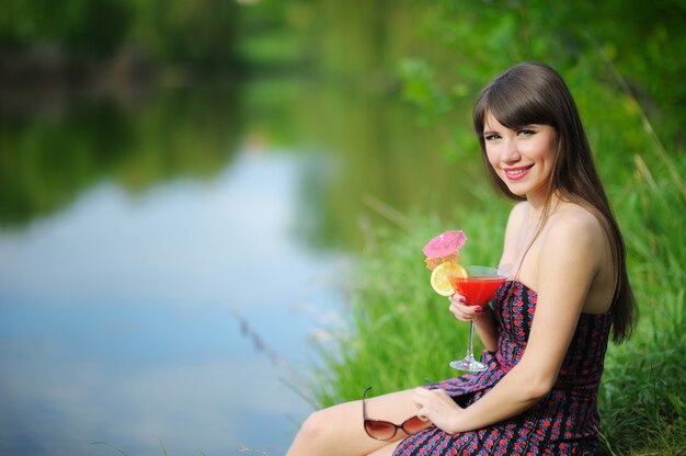 Ragazza con cocktail in natura