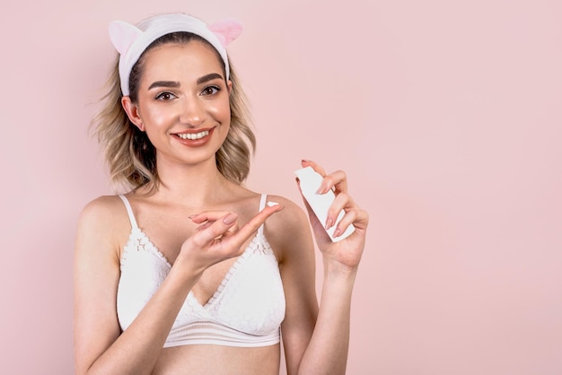 Ragazza con crema per il viso o siero per la cura della pelle del viso