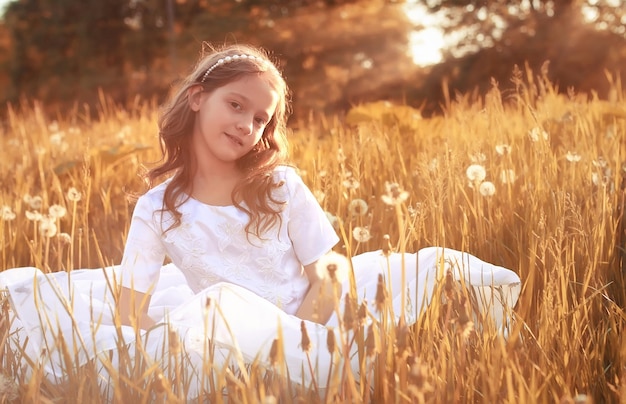 Ragazza con dundelion nel parco autunnale