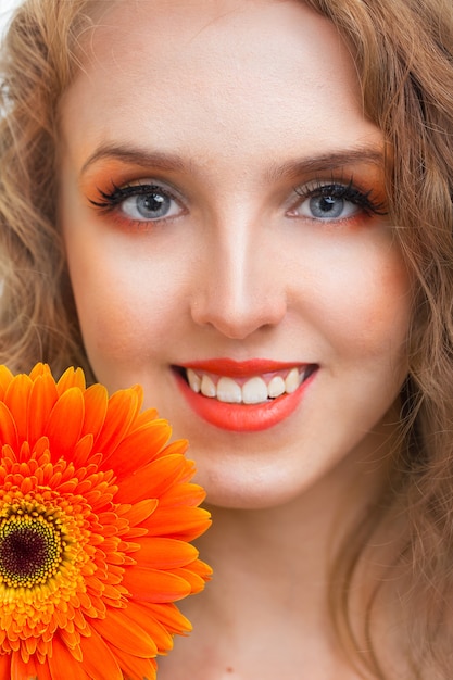 Ragazza con fiore di gerbera in studio