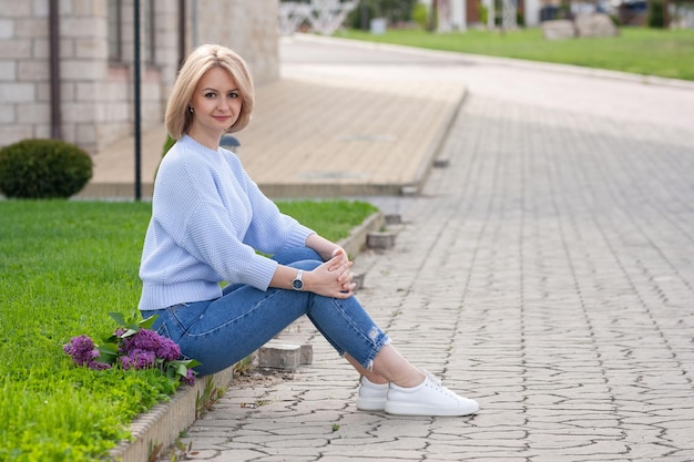 ragazza con fiori che riposano sulla strada