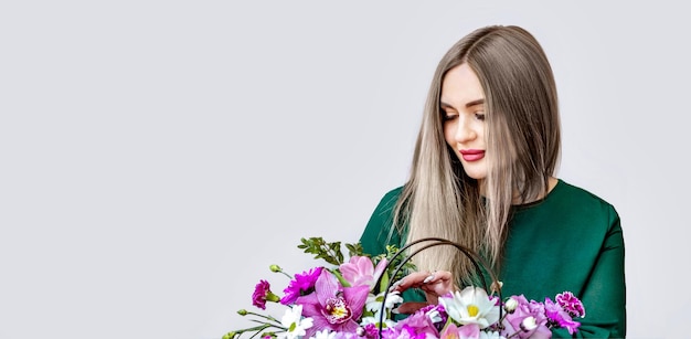 Ragazza con fiori nelle sue mani su uno sfondo bianco