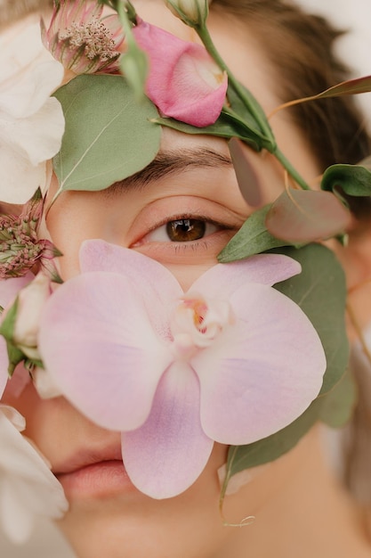 Ragazza con fiori sul viso Colpo artistico di una donna orchidea sul viso