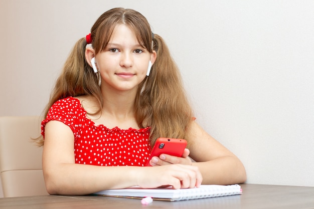 Ragazza con fossette sulle guance con un telefono e cuffie wireless