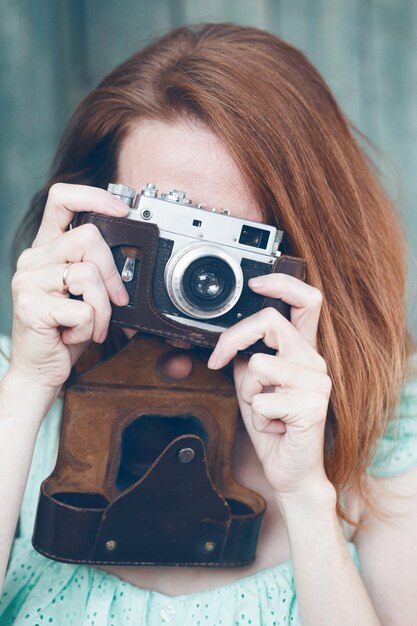 Ragazza con fotocamera retrò. Vintage ▾.