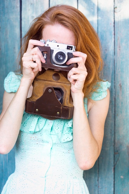 Ragazza con fotocamera retrò. Vintage ▾.