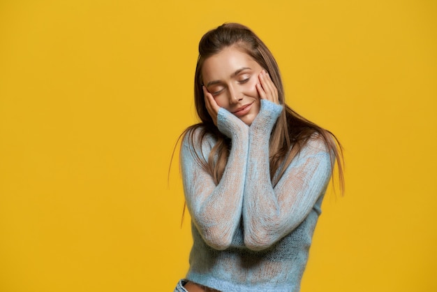 Ragazza con gli occhi chiusi che si toccano le guance