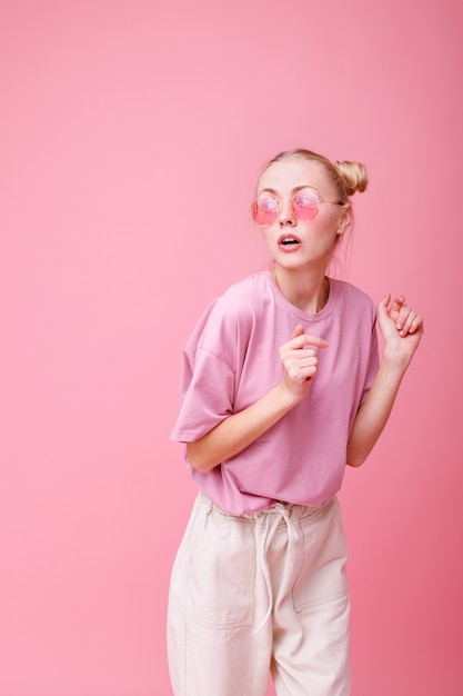 Ragazza con gli occhiali sul rosa