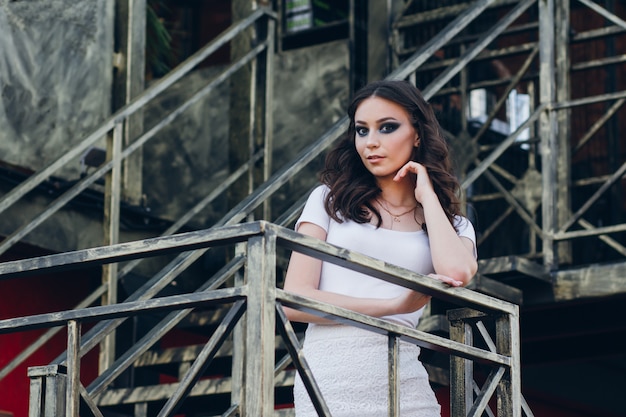 Ragazza con i capelli lunghi in elegante abito bianco