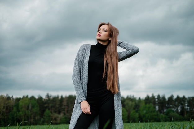 Ragazza con i capelli lunghi in piedi nel campo nel vento Concetto di libertà e passione