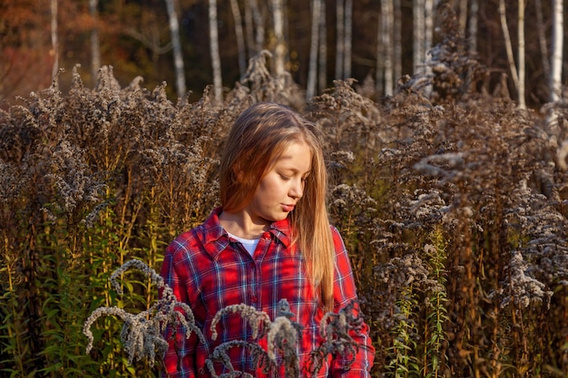 Ragazza con i capelli lunghi nella foresta autunnale