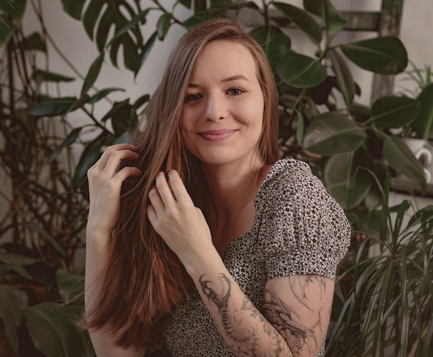 Ragazza con i capelli lunghi sullo sfondo del fogliame