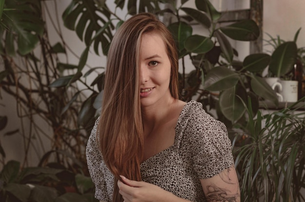 Ragazza con i capelli lunghi sullo sfondo del fogliame