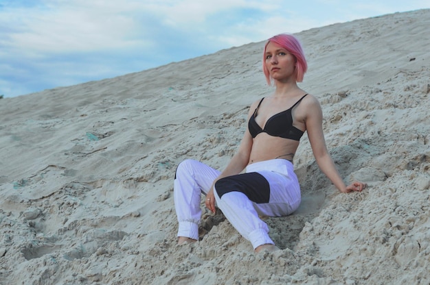 Ragazza con i capelli rosa in costume da bagno contro il cielo