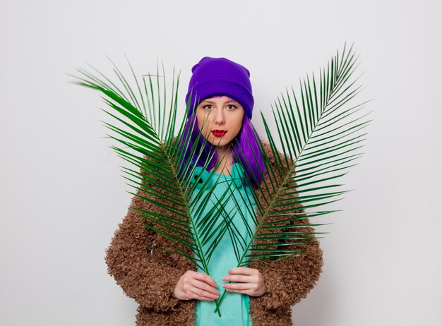 ragazza con i capelli viola in giacca con foglia di palma