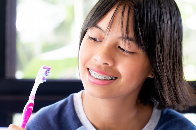 Ragazza con i denti delle parentesi graffe che sorride e felice