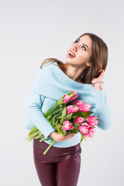 Ragazza con i tullips che stanno sul bacground grigio