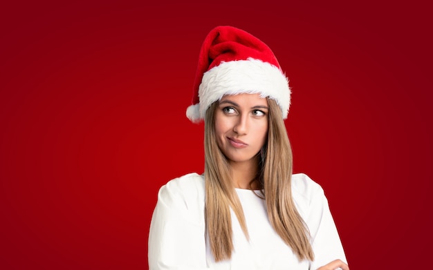 Ragazza con il cappello di natale che pensa un'idea