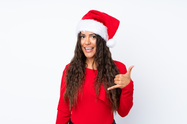 Ragazza con il cappello di natale sopra fondo bianco isolato che fa gesto del telefono